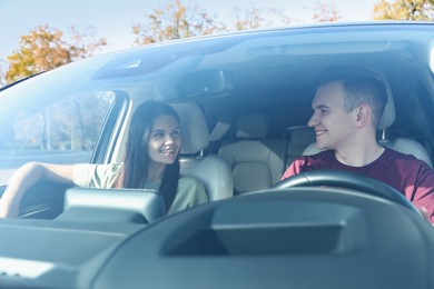 Photo of Happy young couple travelling together by car