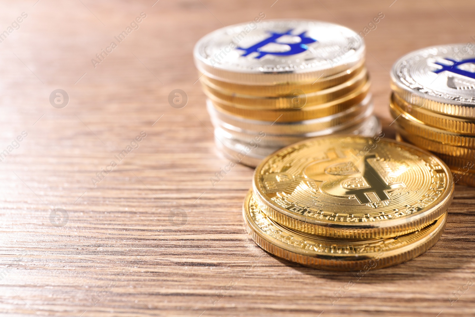 Photo of Shiny bitcoins on wooden background, space for text. Digital currency