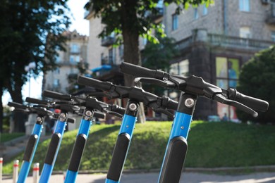 Many modern electric scooters on city street, closeup. Rental service