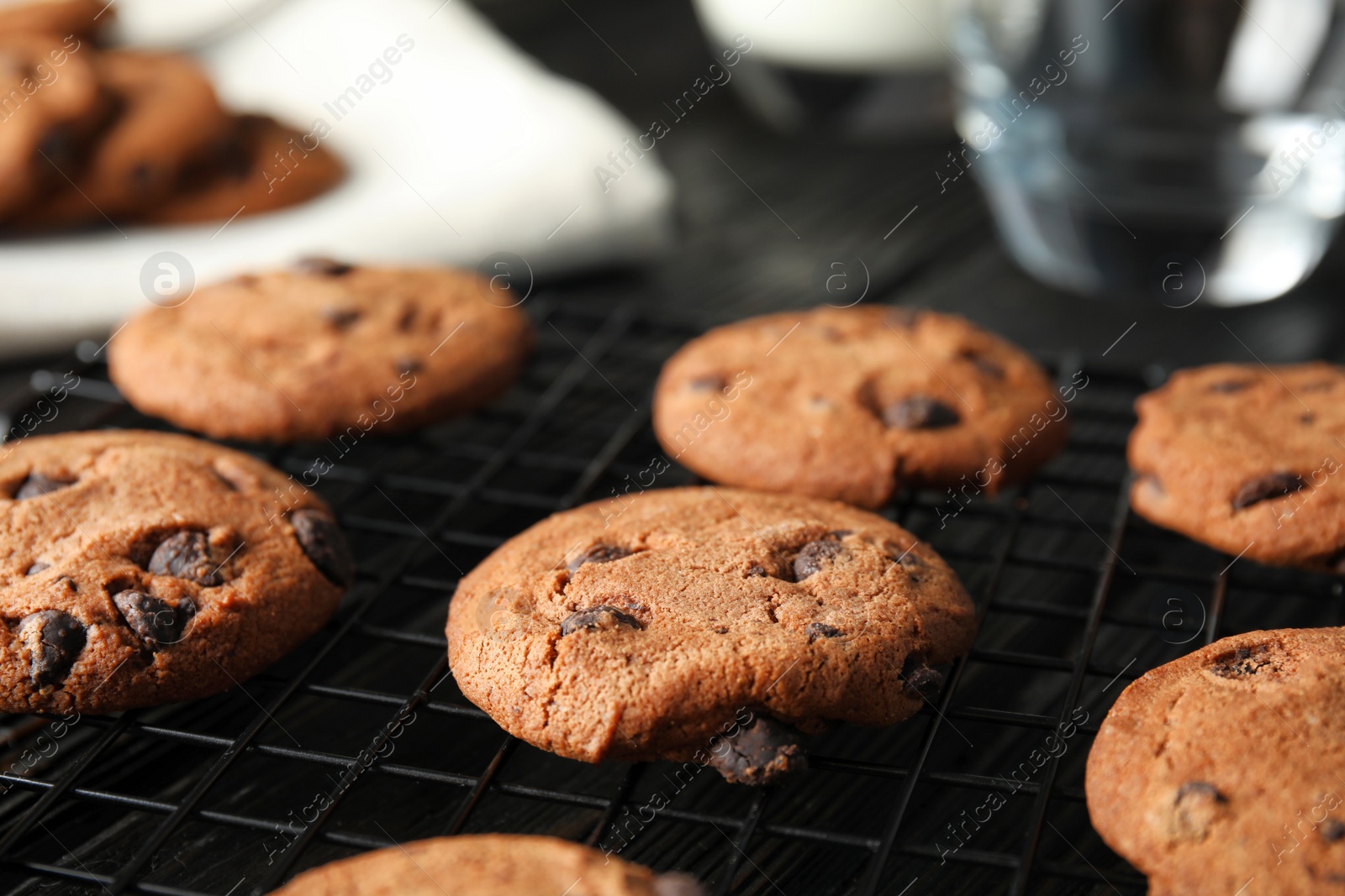 Photo of Cooling rack with chocolate chip cookies on wooden background
