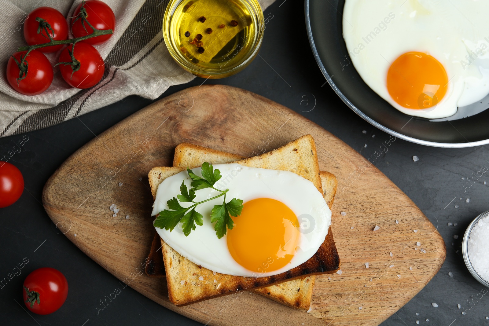 Photo of Flat lay composition with tasty fried eggs on black table