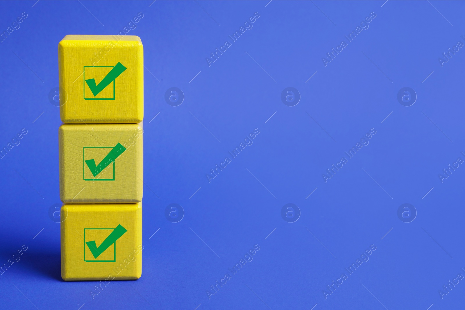 Image of Stacked cubes with check marks on blue background. Space for text