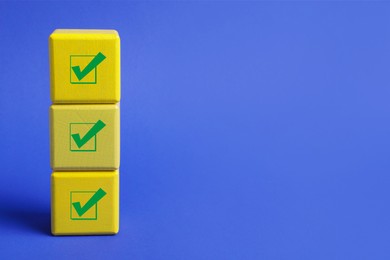 Stacked cubes with check marks on blue background. Space for text