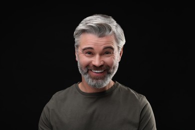 Photo of Personality concept. Portrait of happy man on black background