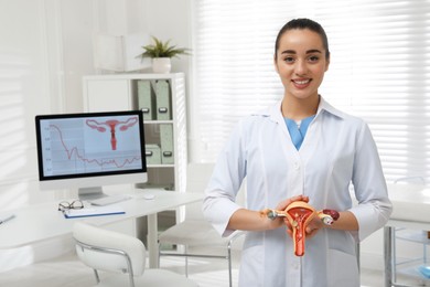 Photo of Gynecologist demonstrating model of female reproductive system in clinic