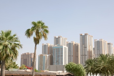 Photo of AJMAN, UNITED ARAB EMIRATES - NOVEMBER 04, 2018: Landscape with modern multi-storey buildings on sunny day
