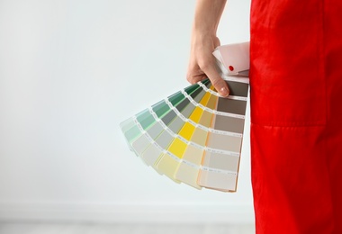 Photo of Female decorator with color palette on white background, closeup