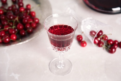 Delicious cherry wine and ripe juicy berries on white table