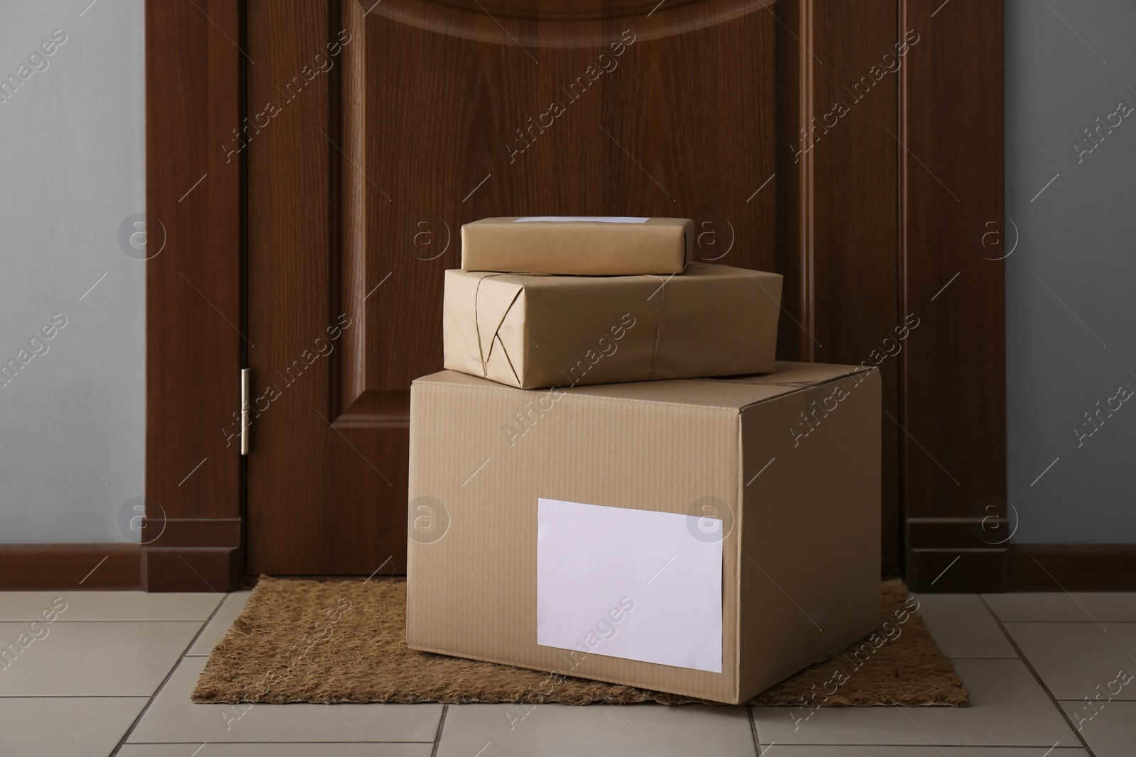 Photo of Parcels on rug near door. Delivery service