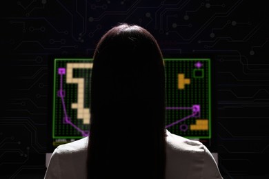 Image of Gaming disorder. Woman playing on computer in darkness, back view