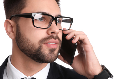 Young businessman talking on smartphone against white background, closeup
