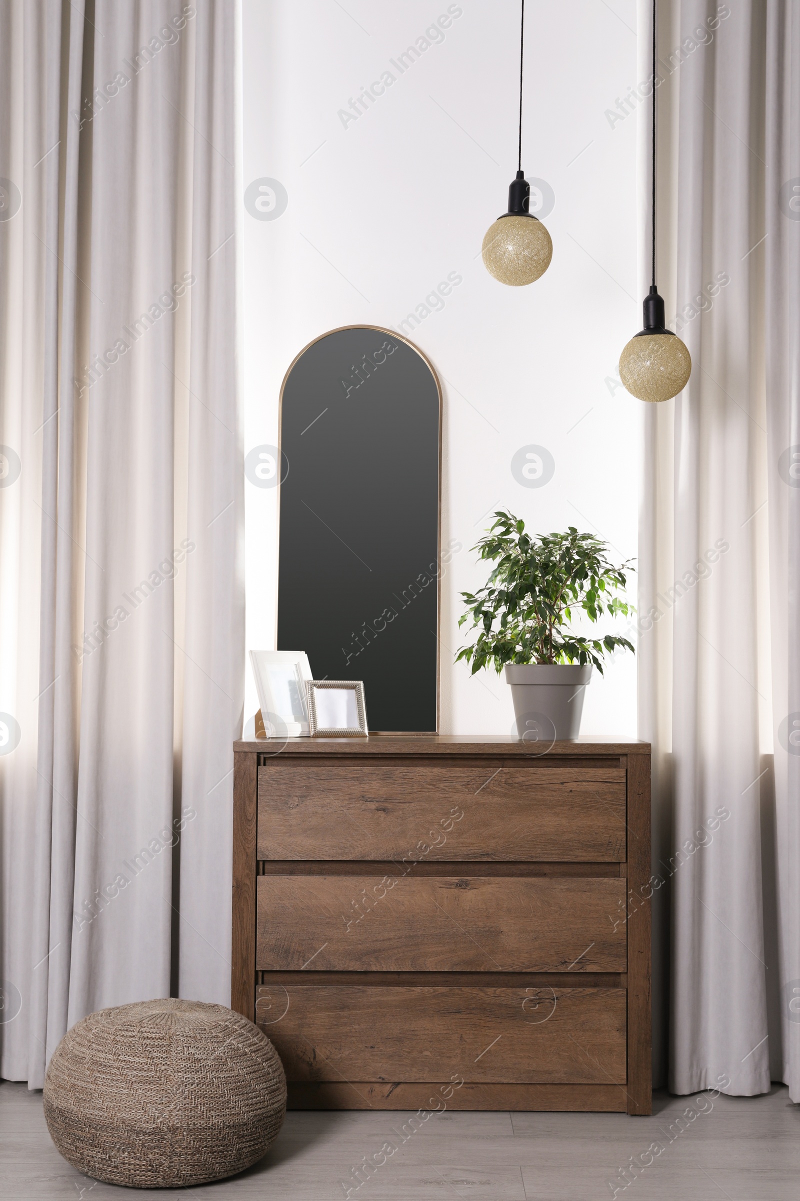 Photo of Stylish room interior with wooden chest of drawers and beautiful decor elements