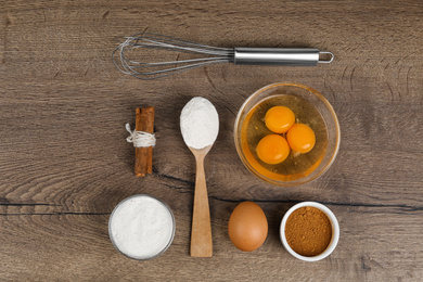 Photo of Flat lay composition with raw eggs and other ingredients on wooden background. Baking pie