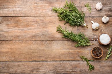 Photo of Flat lay composition with fresh rosemary on wooden table. Space for text