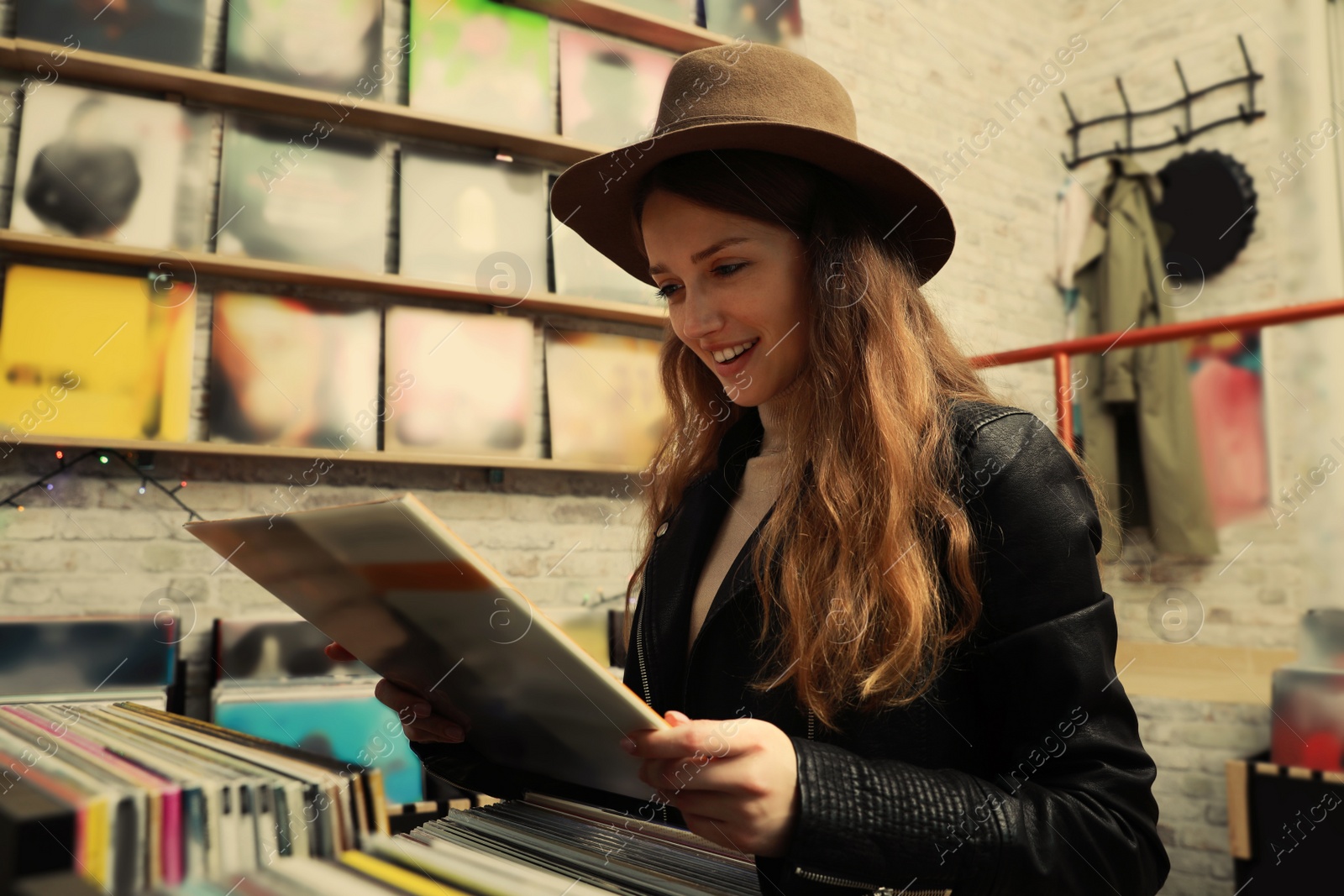 Image of Young woman with vinyl record in store