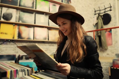 Young woman with vinyl record in store