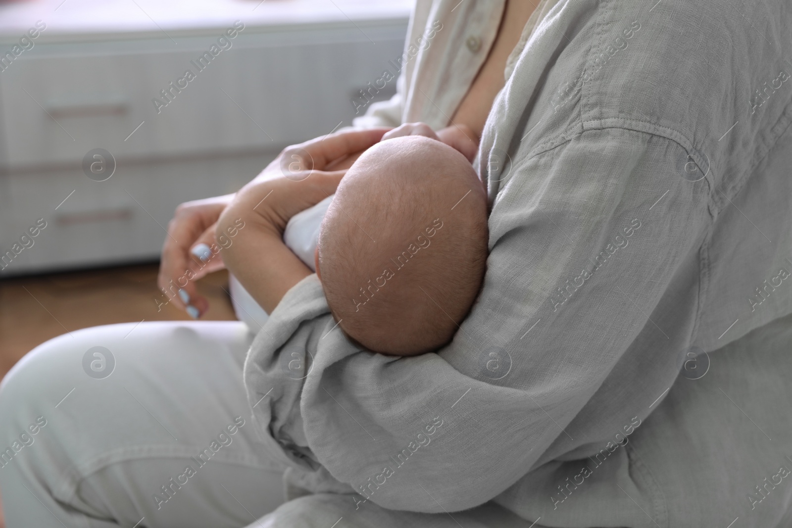 Photo of Mother holding her sleeping baby at home, closeup