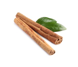 Photo of Cinnamon sticks and green leaves isolated on white