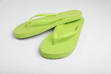 Photo of Stylish light green flip flops on white background