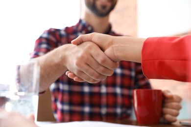 Photo of Business partners shaking hands after meeting, closeup