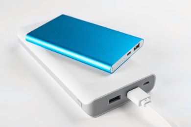 Photo of Modern external portable chargers on white 
 background