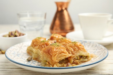 Delicious baklava with pistachios on white wooden table, closeup