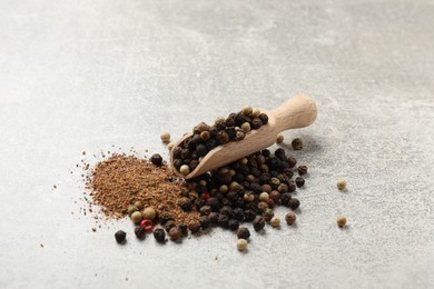 Photo of Aromatic spice. Ground and whole peppers in scoop on light grey table