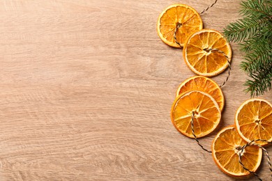 Photo of Handmade garland from dry orange slices on wooden table, flat lay. Space for text