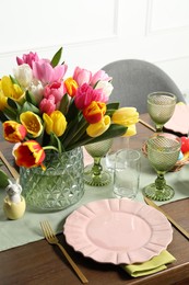 Photo of Easter celebration. Festive table setting with beautiful flowers and painted eggs