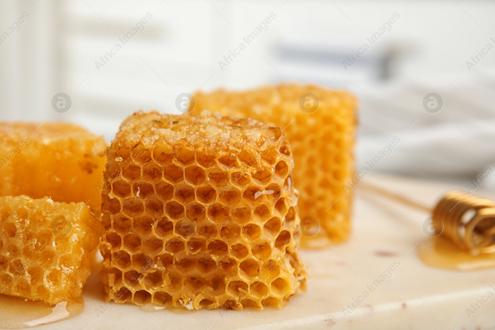 Photo of Fresh delicious honeycombs on white board, closeup