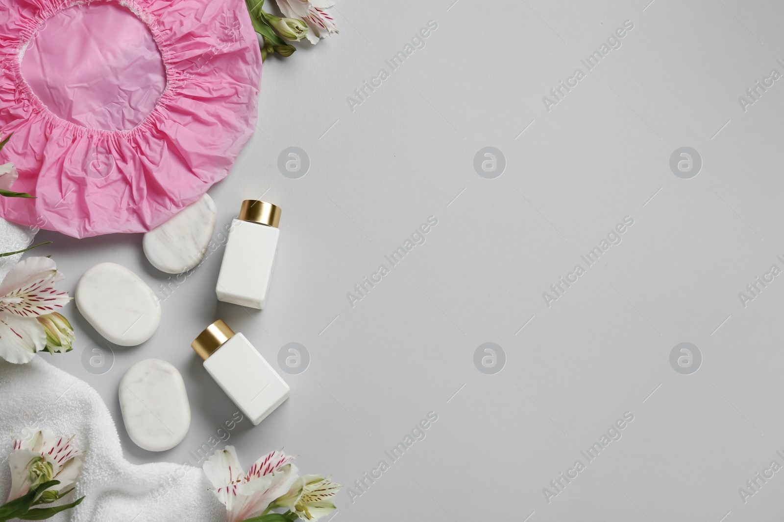 Photo of Flat lay composition with shower cap and spa stones on grey background. Space for text