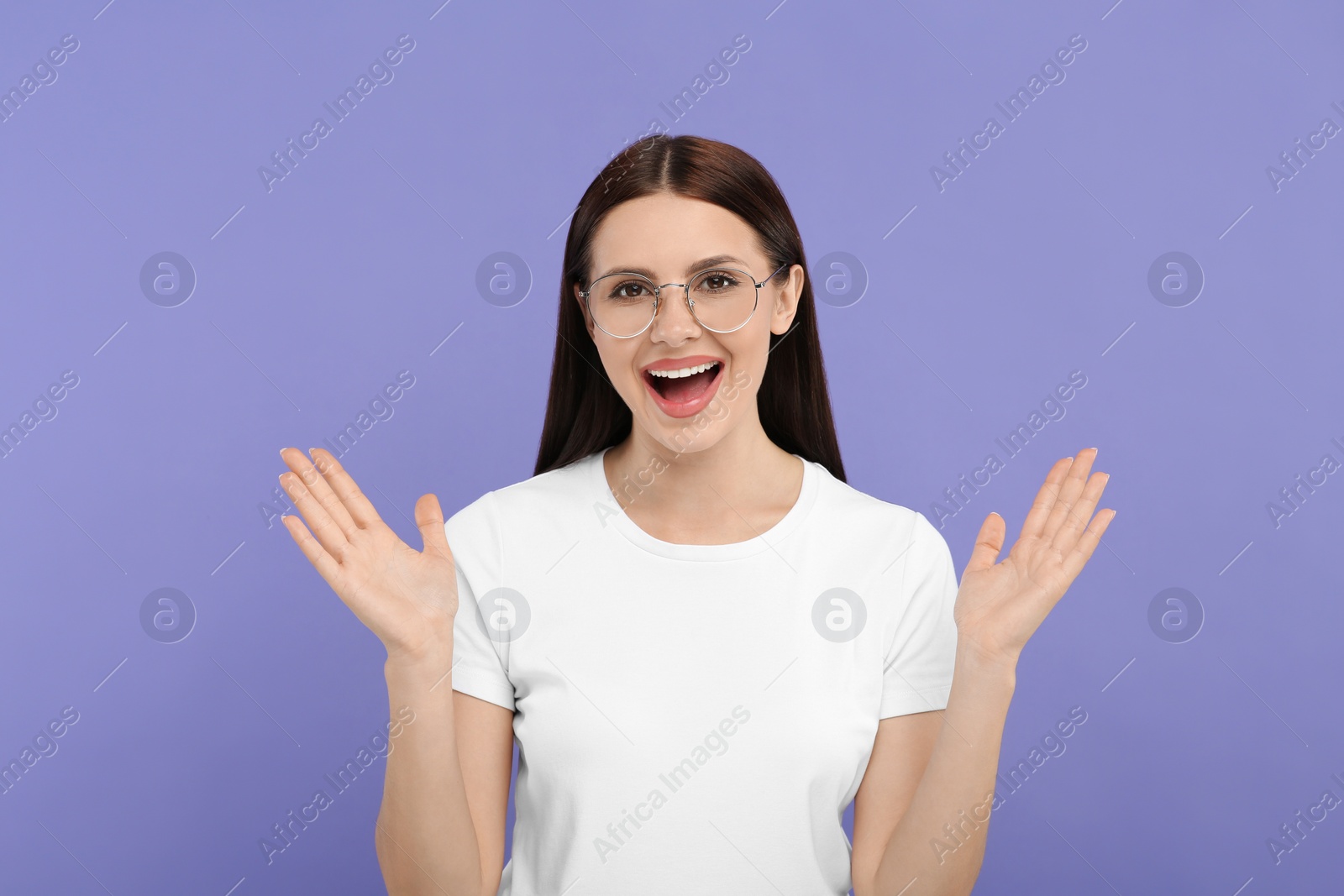 Photo of Portrait of emotional woman in stylish eyeglasses on violet background