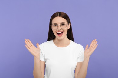 Photo of Portrait of emotional woman in stylish eyeglasses on violet background