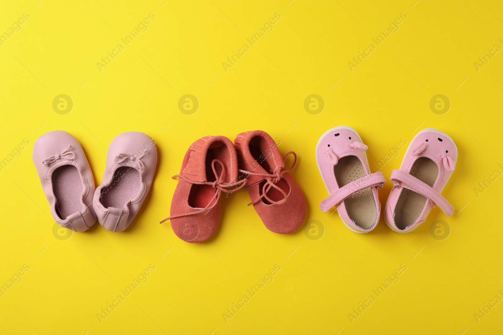 Photo of Flat lay composition with cute child shoes on color background