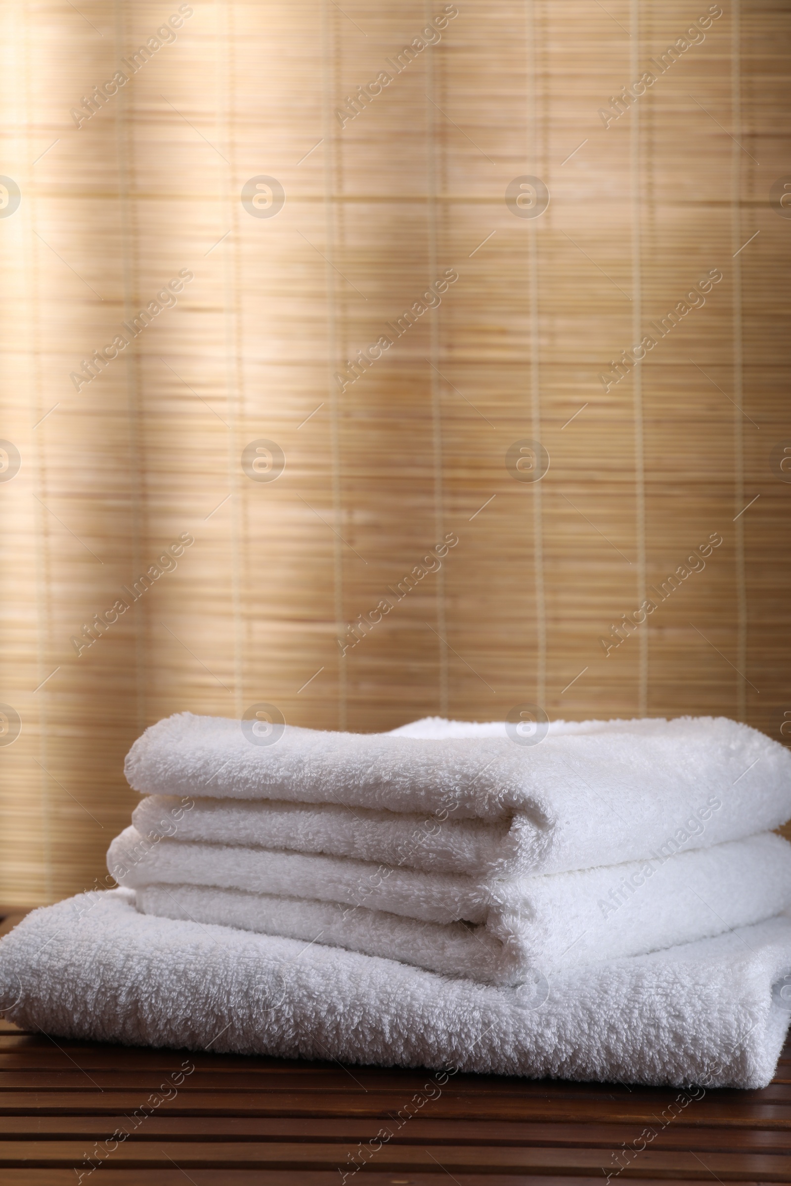 Photo of Stacked soft towels on wooden table indoors