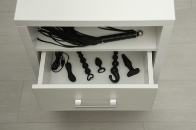 Photo of Different sex toys in drawer indoors, above view