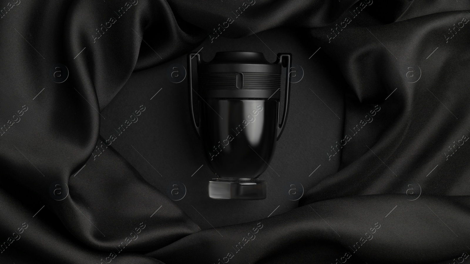 Photo of Bottle of luxurious perfume and silk fabric on black background, top view