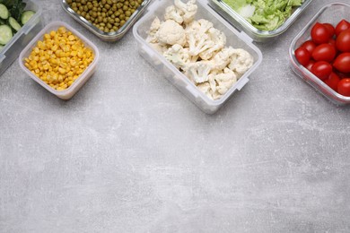 Photo of Glass and plastic containers with different fresh products on light grey table, flat lay. Space for text