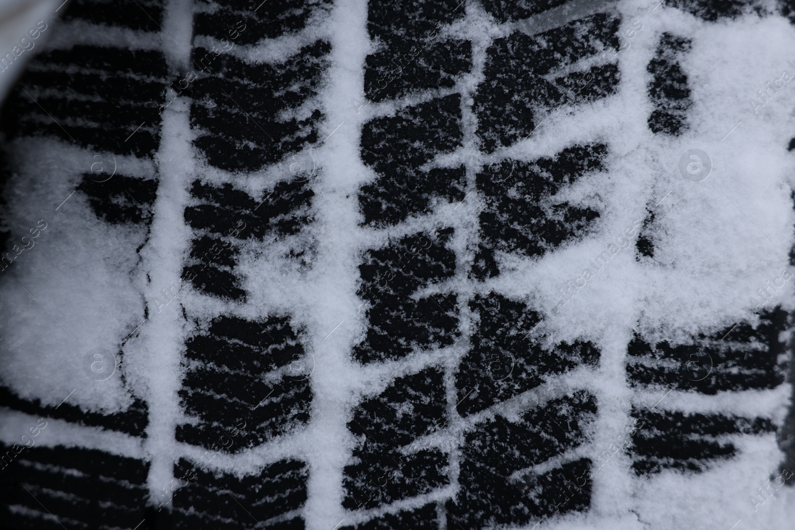 Photo of Winter tire covered with snow, closeup view