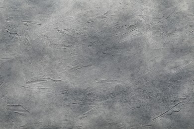 Photo of Light gray textured surface as background, top view