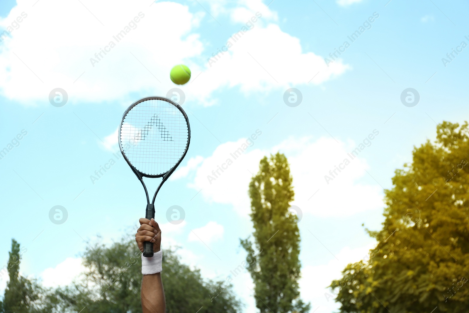 Photo of Sportsman playing tennis outdoors on sunny day, closeup