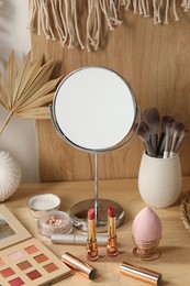 Dressing table with mirror and makeup products in room