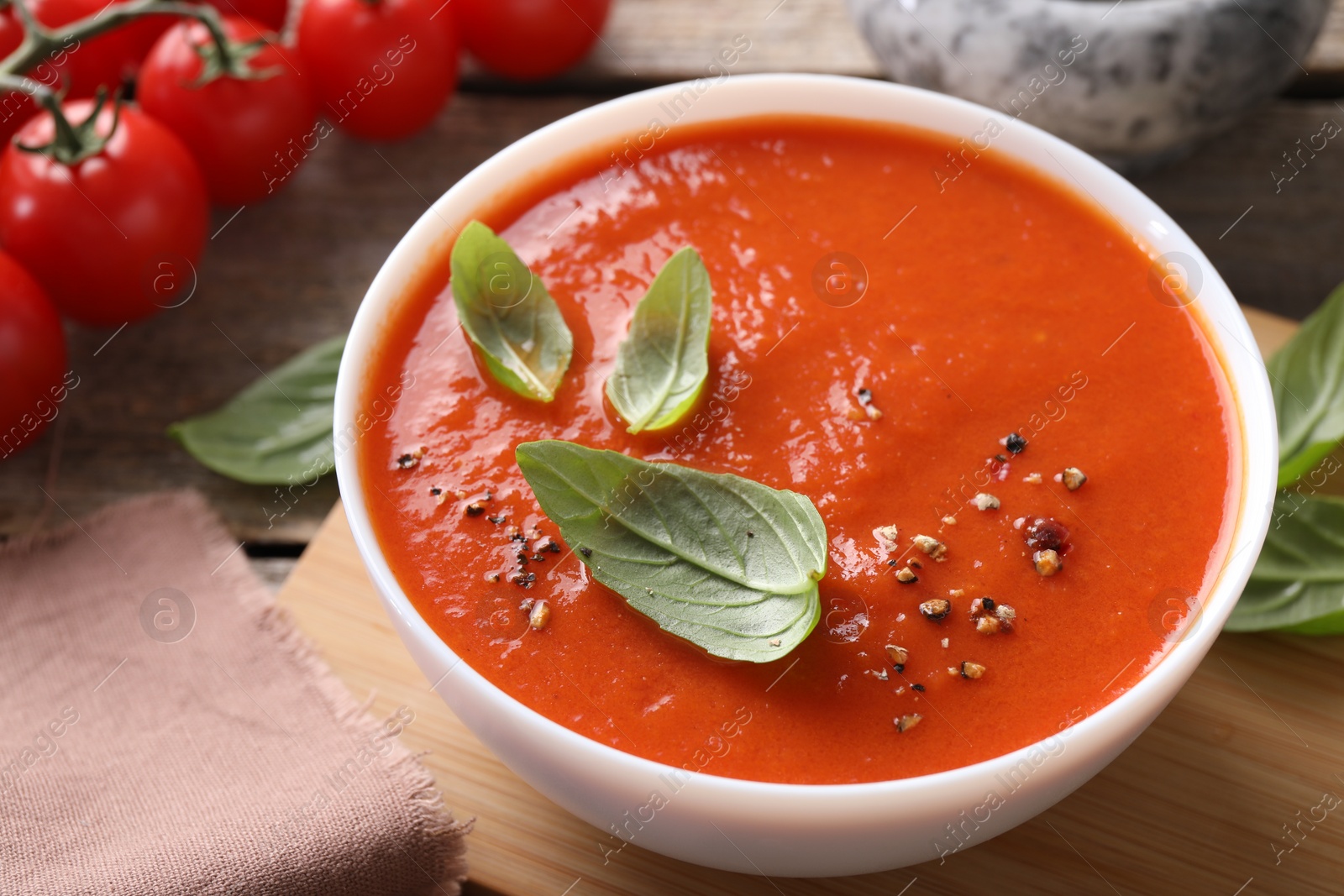 Photo of Delicious tomato soup with basil and spices on table, closeup