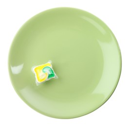 Photo of Green plate with dishwasher detergent pod on white background, top view