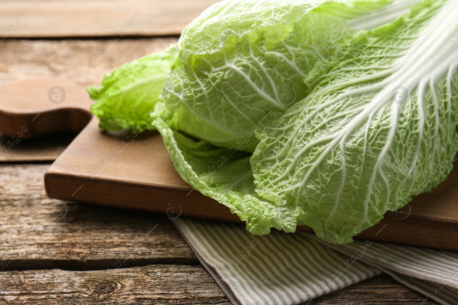 Photo of Fresh ripe Chinese cabbage on wooden table, closeup