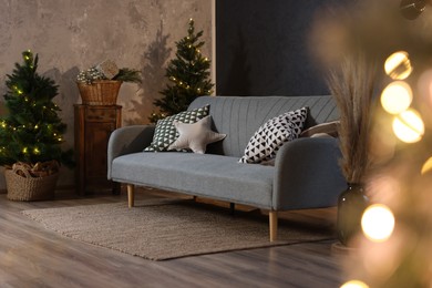 Stylish living room with comfortable sofa and Christmas tree. Interior design