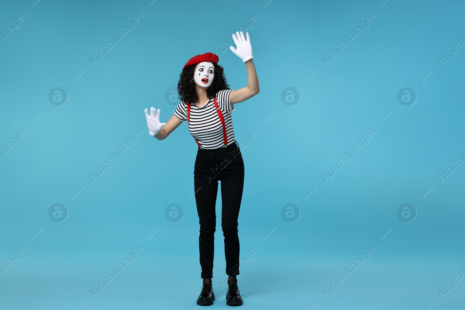 Photo of Funny mime with beret posing on light blue background