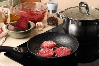 Photo of Cooking vegan cutlets in frying pan on stove