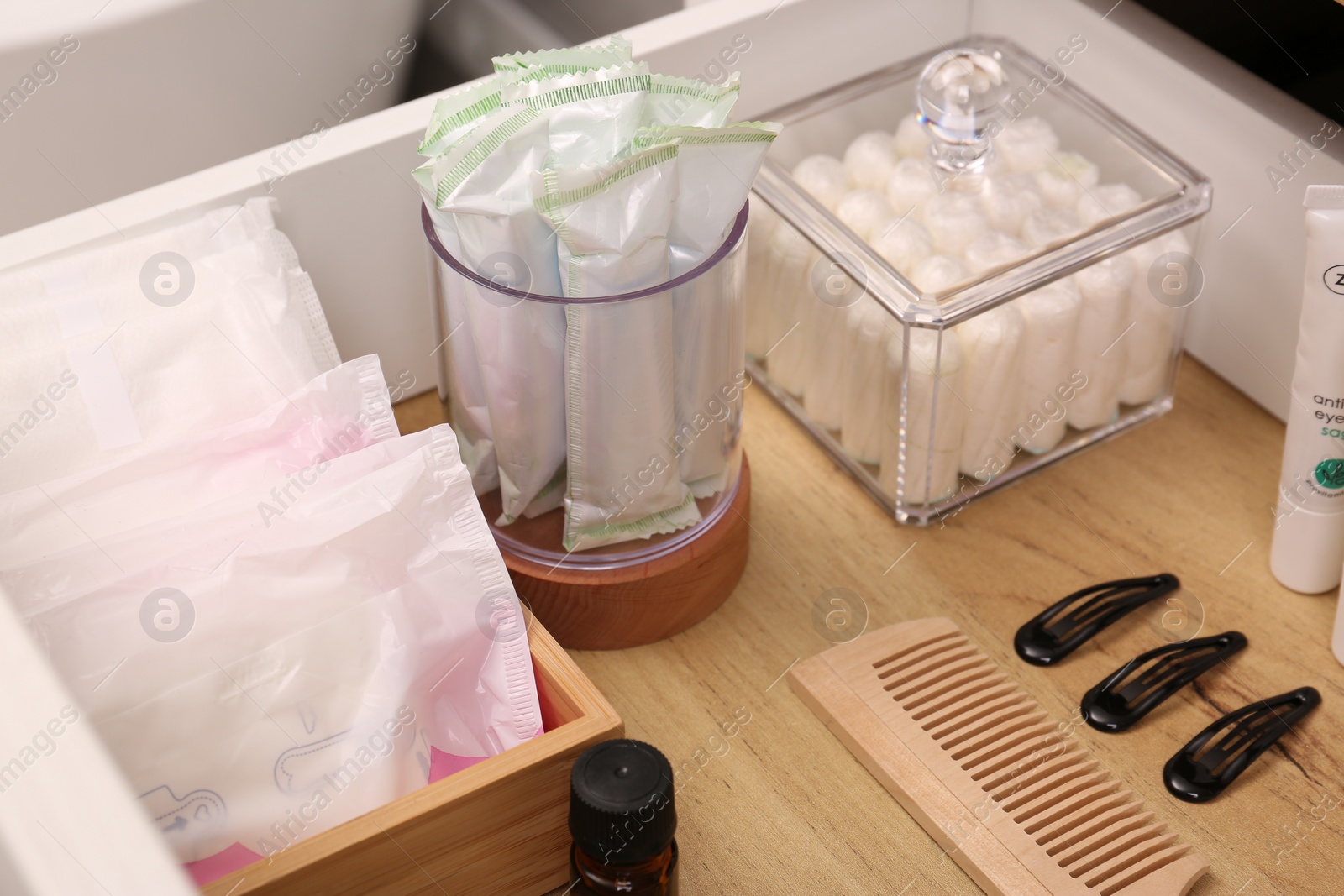 Photo of Open cabinet drawer with tampons and feminine hygiene products indoors, closeup