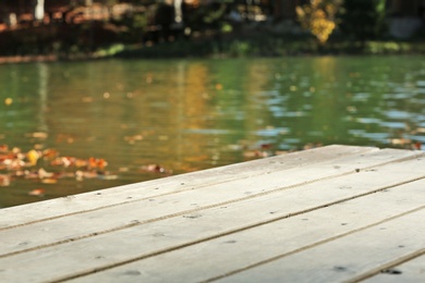 Wooden pier near pond. Space for text